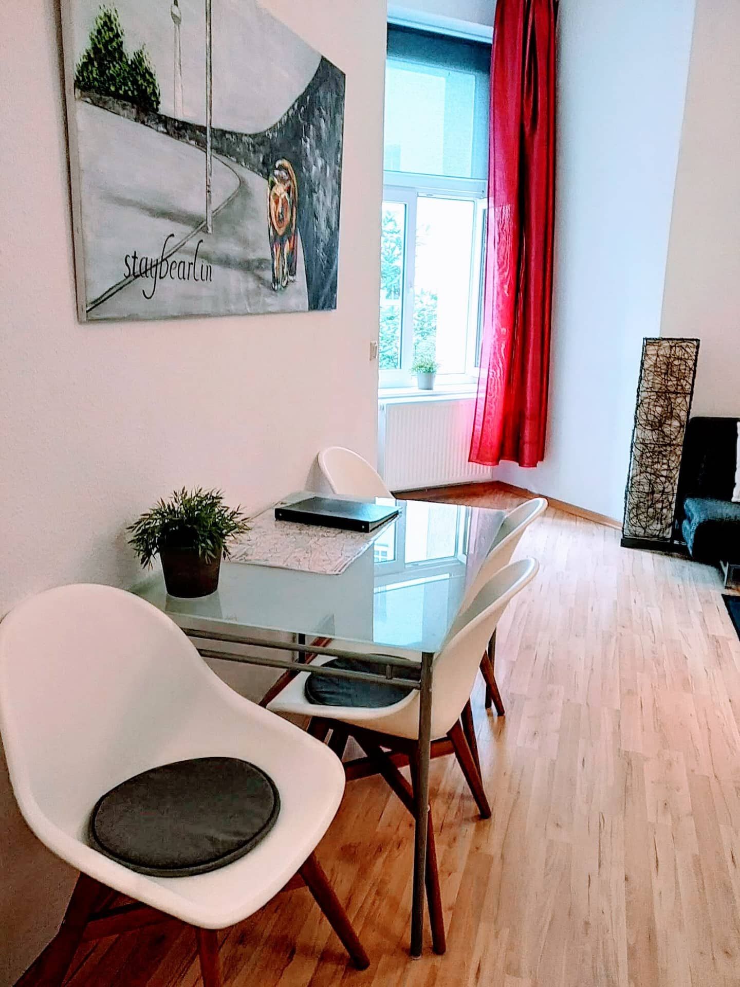 Unsere Ferienwohnung in der Nähe vom Mauerpark hat ein Wohnzimmer mit einem Tisch und Stühlen und einem Gemälde an der Wand.