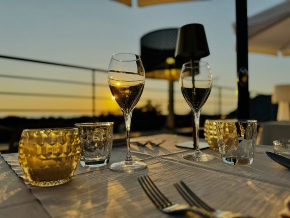 Sala elegante di un ristorante di mare con luci soffuse, tavoli curati e atmosfera accogliente sul mare.