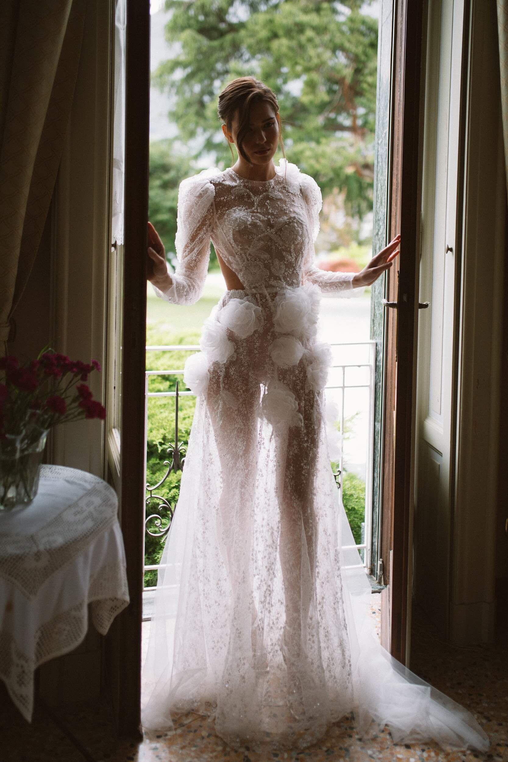 Eine Frau in einem Brautkleid steht in einem Türrahmen.