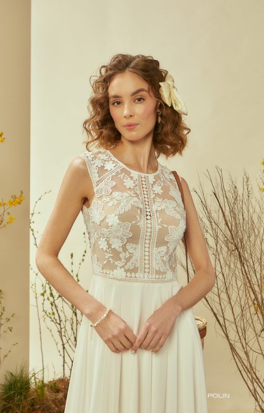 Eine Frau trägt ein weißes Brautkleid und hat eine Blume im Haar.