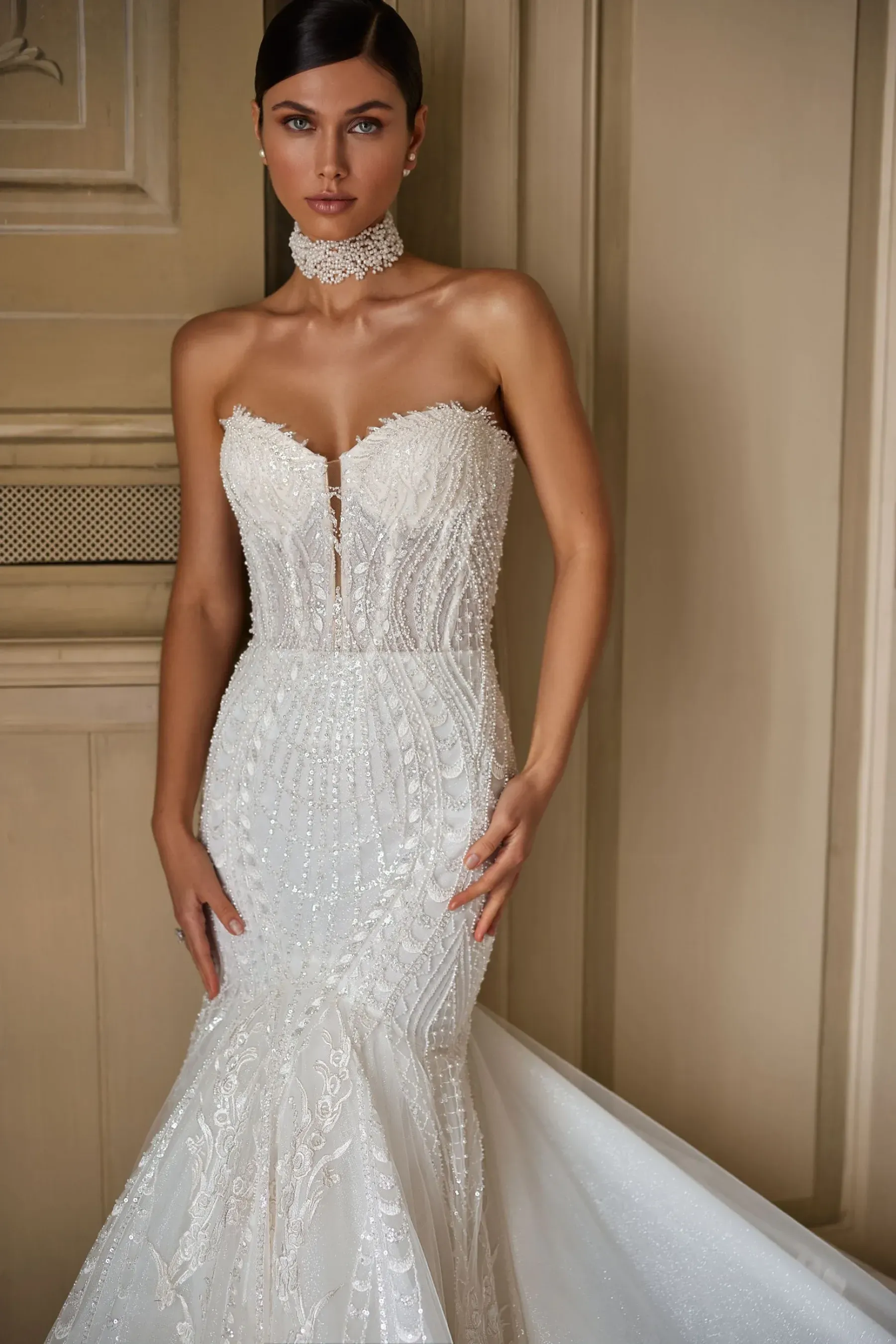 Eine Frau trägt ein weißes Brautkleid und eine Halskette.