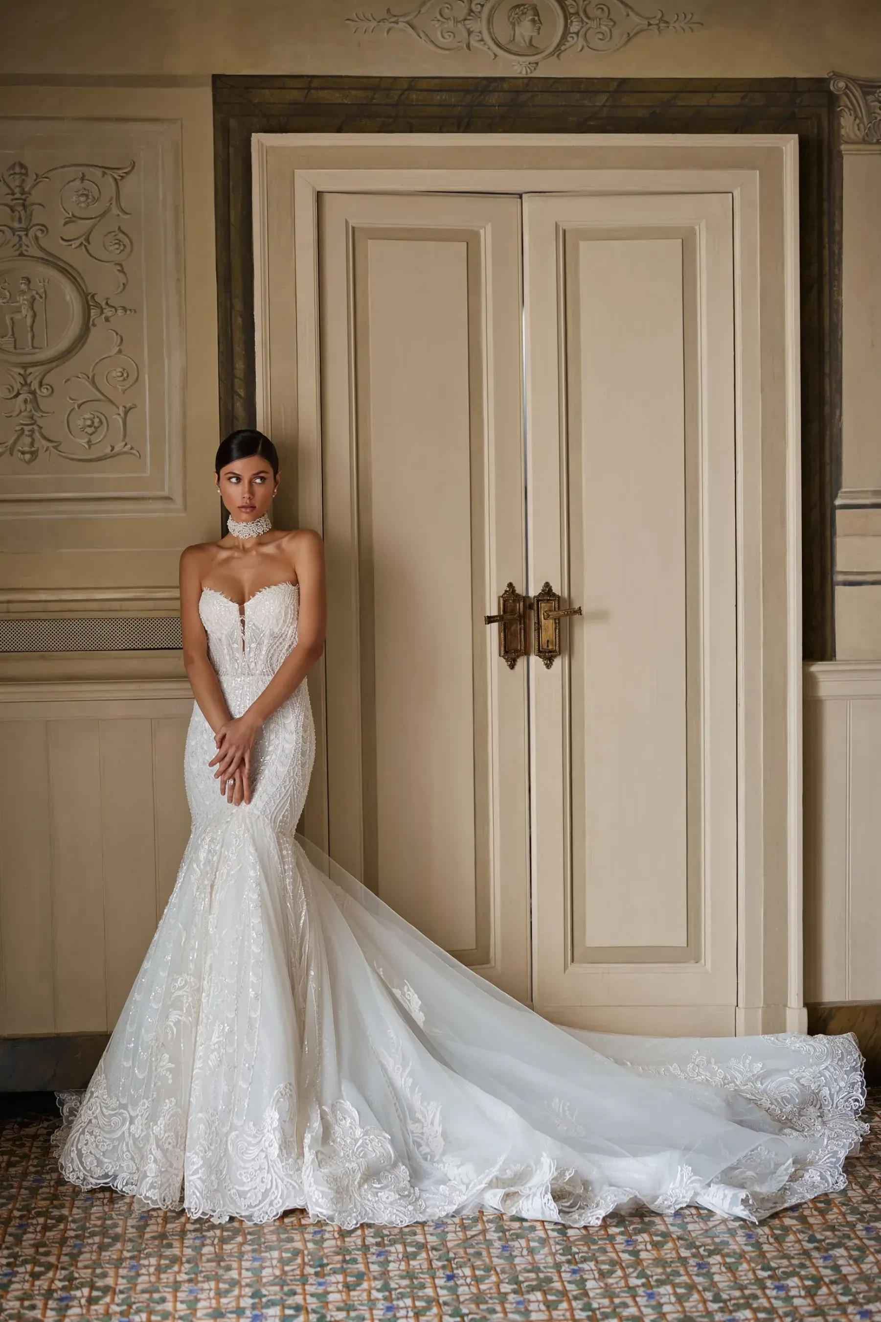 Eine Frau in einem Brautkleid steht vor einer Tür.