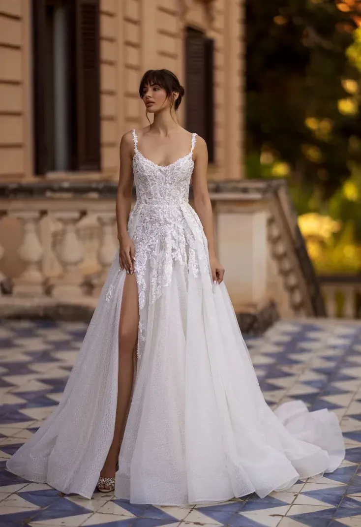 Eine Frau trägt ein weißes Brautkleid mit hohem Schlitz.