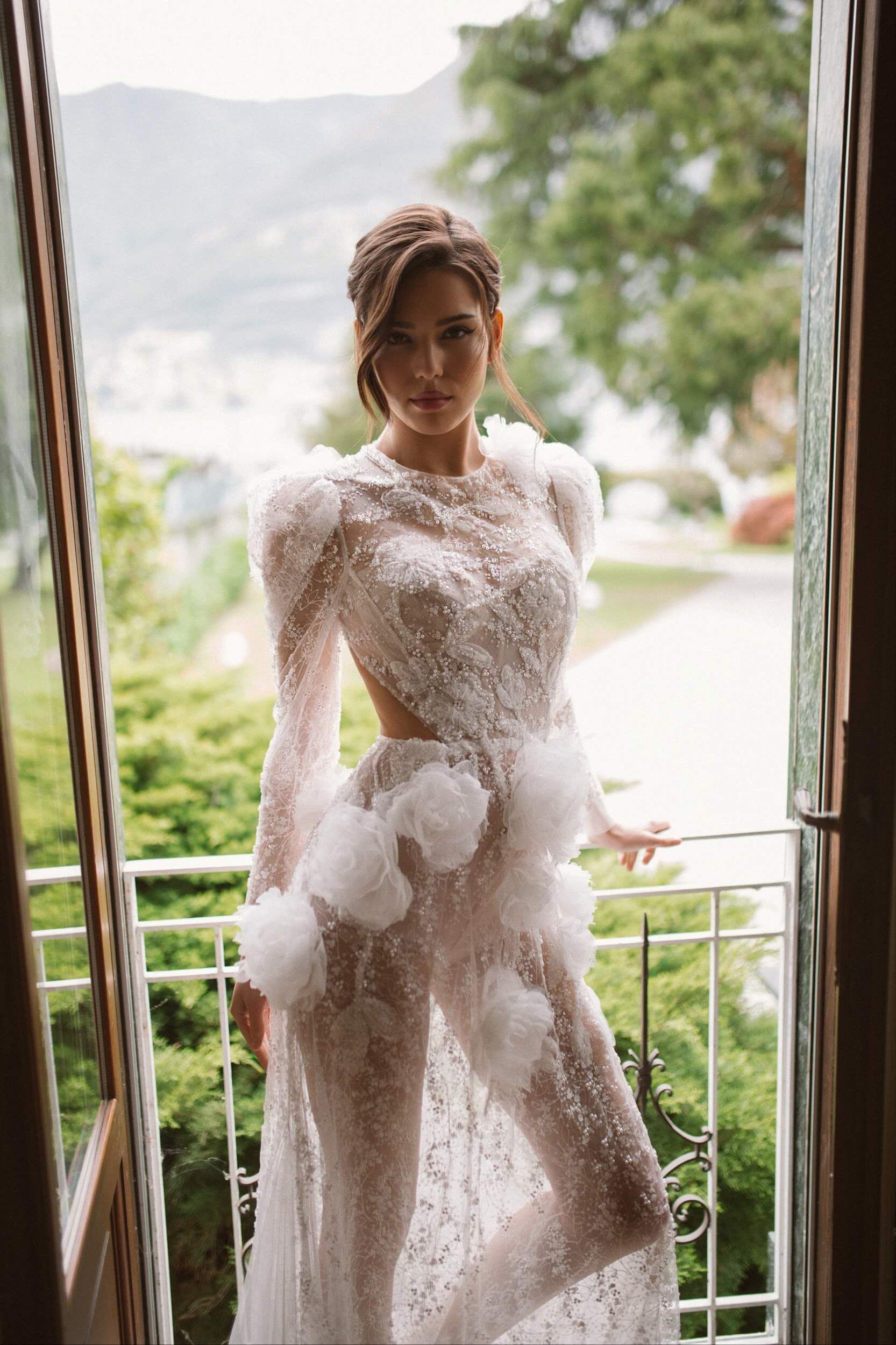 Eine Frau in einem Brautkleid steht auf einem Balkon.