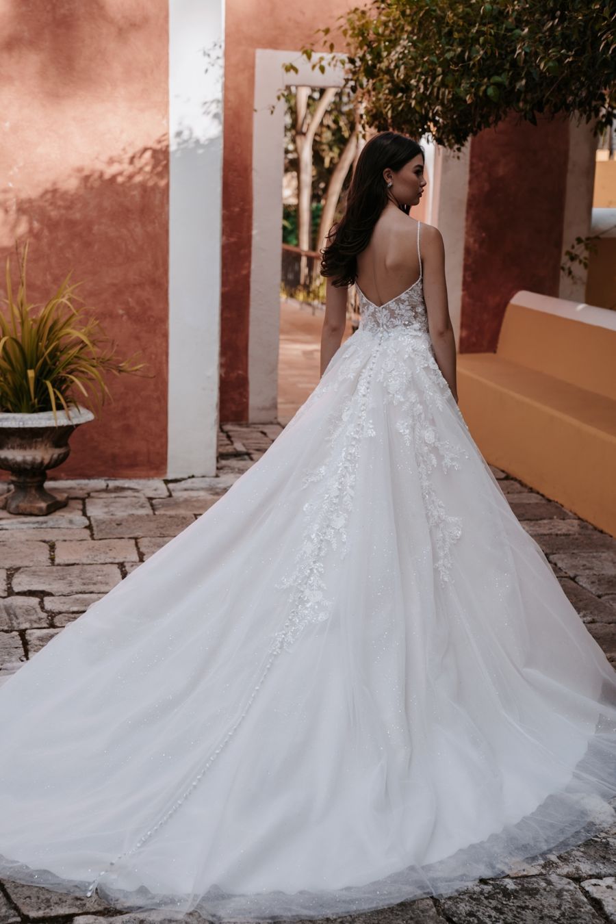 Eine Frau in einem weißen Brautkleid steht vor einem Gebäude.