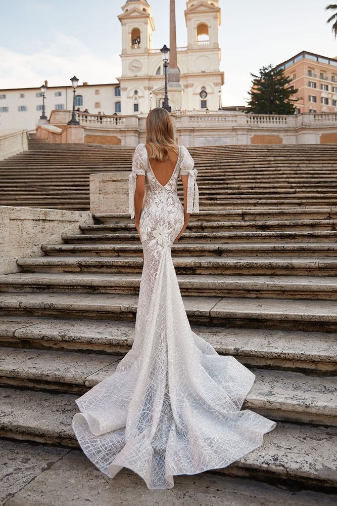 Eine Frau in einem Brautkleid steht auf einer Treppe.