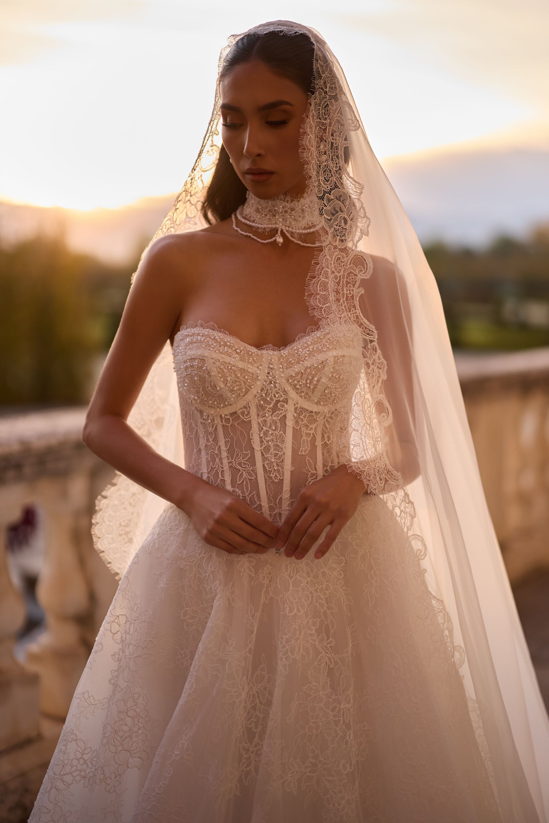 Eine Frau in einem weißen Brautkleid steht vor einem Gebäude.