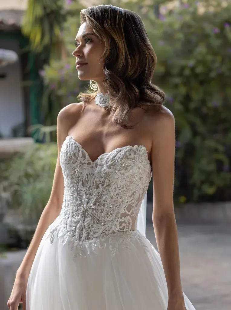 Eine Frau in einem Brautkleid lehnt an einer Säule.