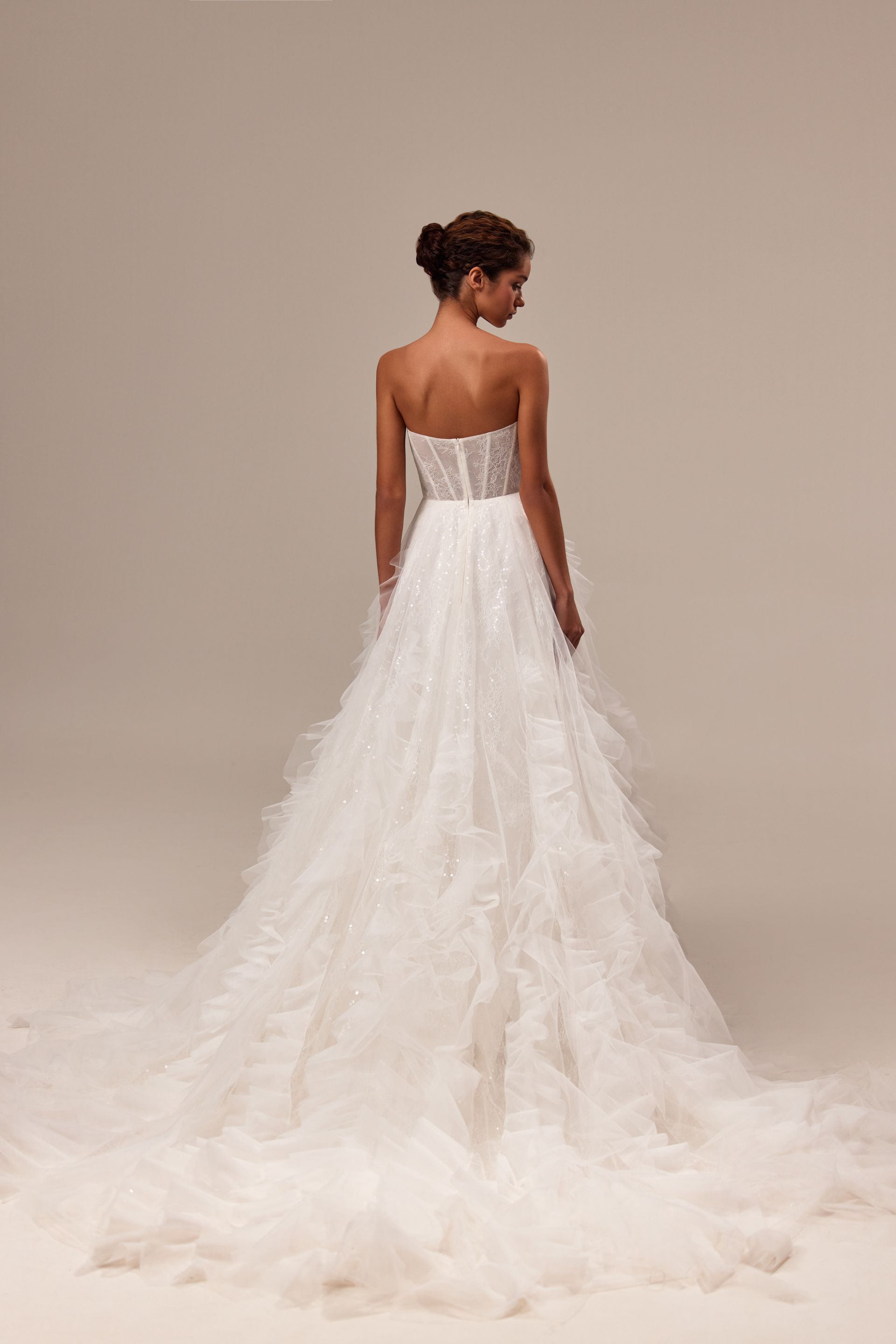 Der Rücken einer Frau in einem weißen Hochzeitskleid.