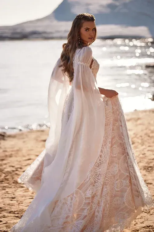 Eine Frau in einem Brautkleid steht an einem Strand.