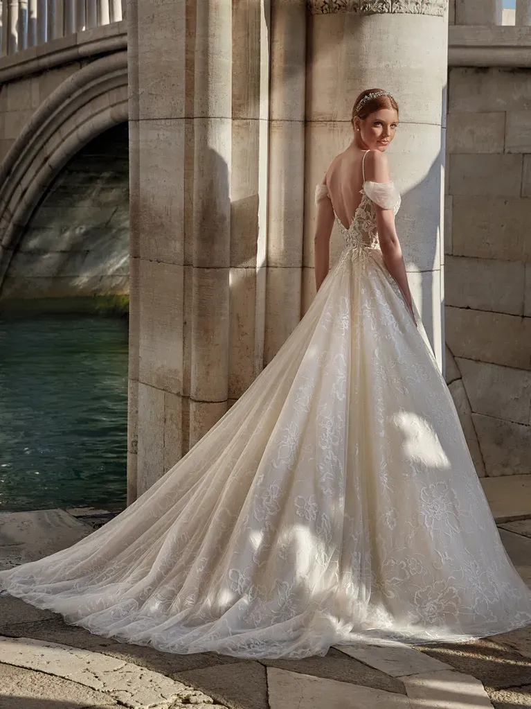 Eine Frau in einem Brautkleid steht vor einer Brücke.