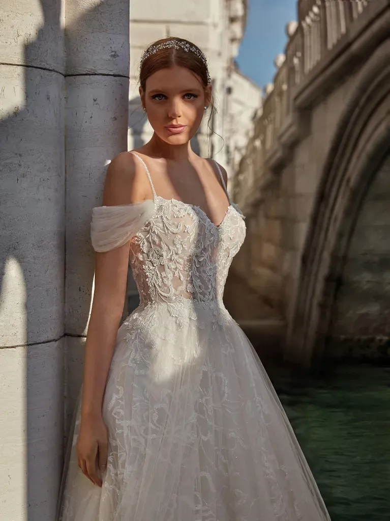 Eine Frau in einem Brautkleid steht neben einer Brücke.