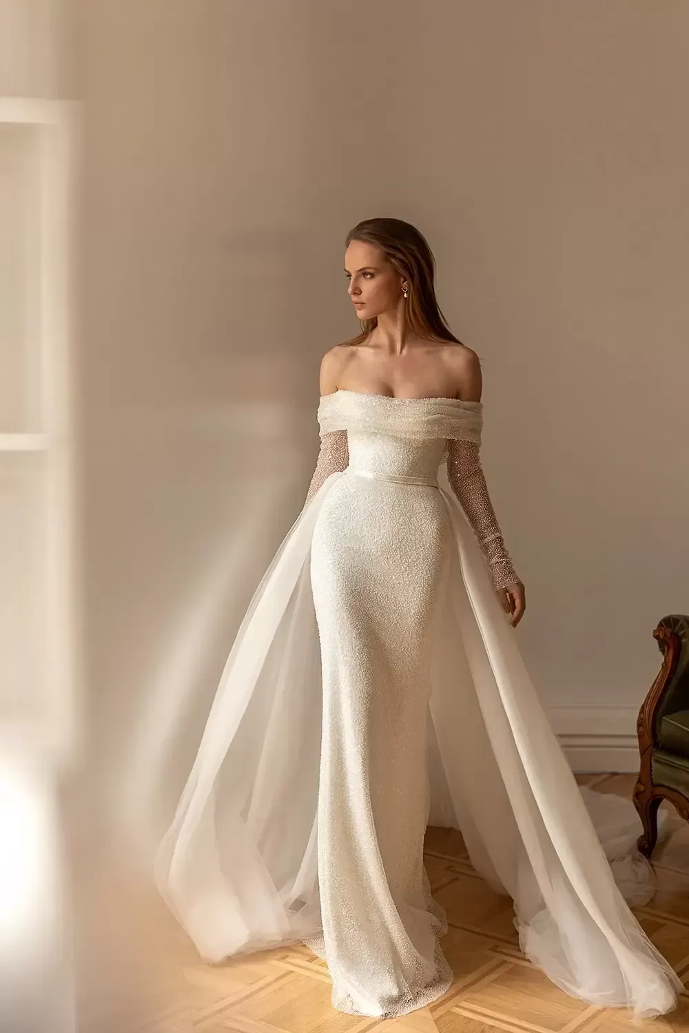 Eine Frau in einem weißen Brautkleid steht in einem Raum.