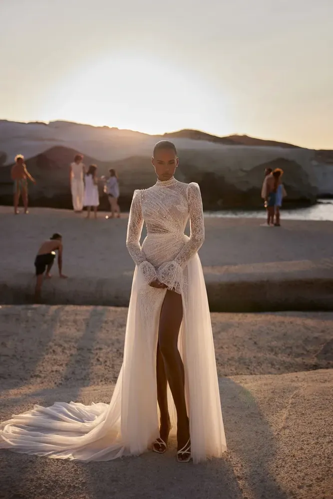 Eine Frau in einem weißen Kleid steht an einem Strand.