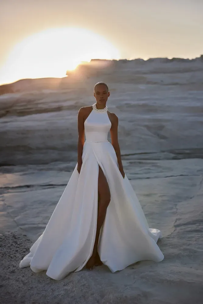 Eine Frau in einem weißen Kleid steht in der Wüste.