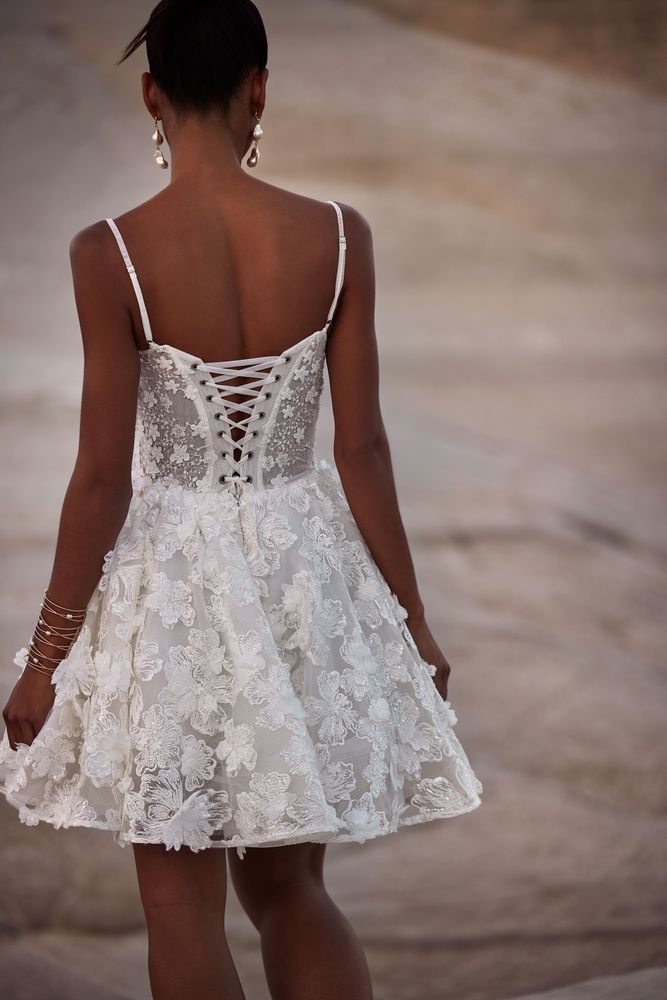 Der Rücken einer Frau in einem weißen Spitzenkleid.