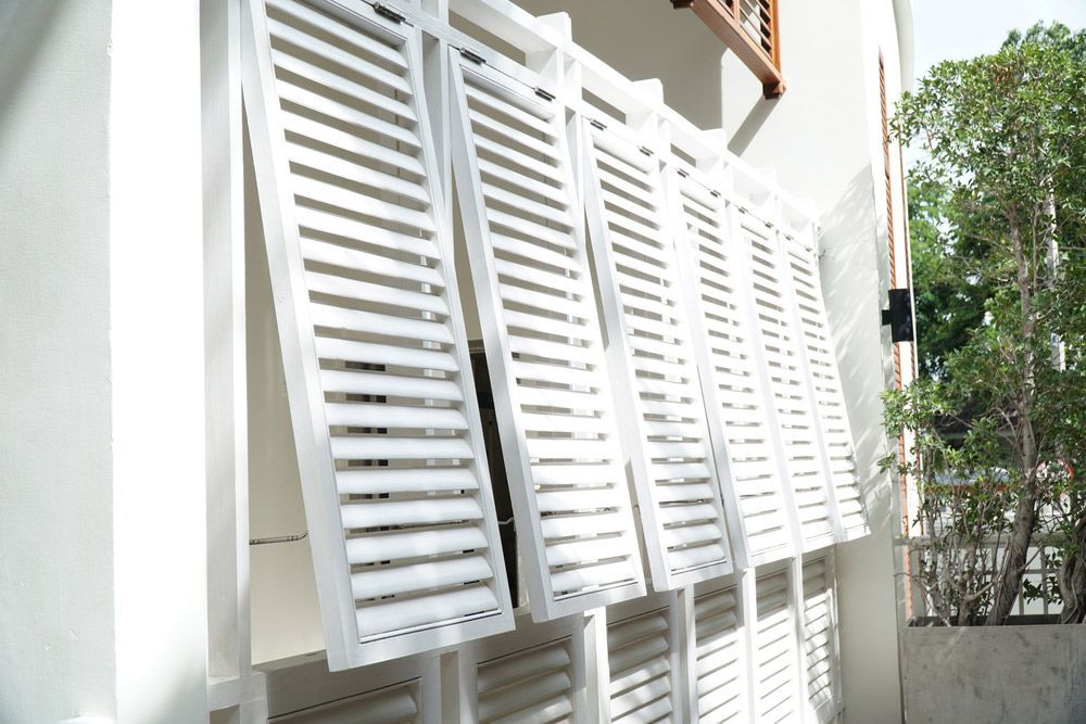A Row Of White Louvres On The Side Of A Building — Readycut Screens & Doors in Winnellie, NT
