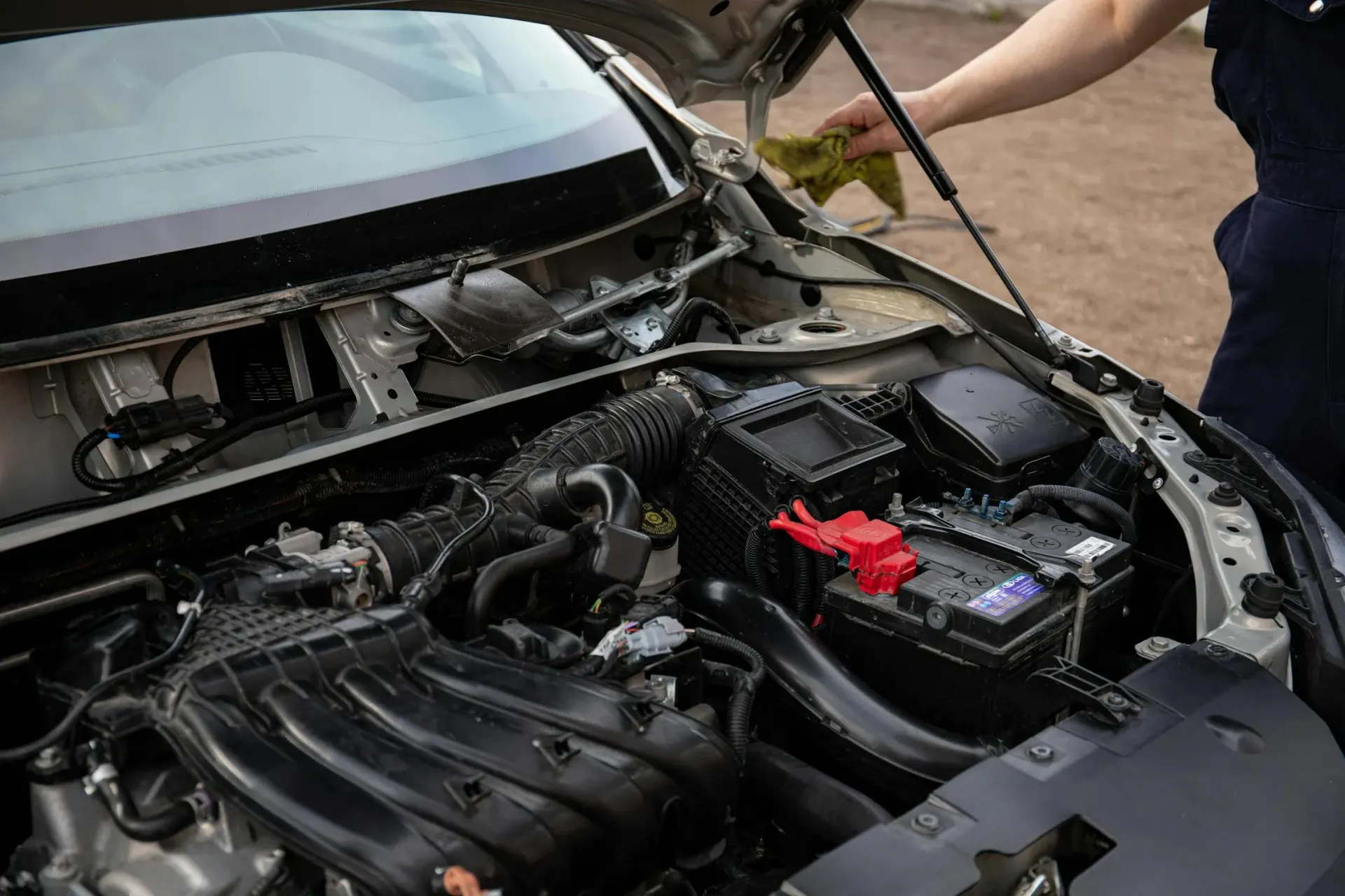 A Person Is Cleaning The Engine Of A Car With A Cloth — Barron River Auto Electrics & Air-conditioning in Stratford, QLD