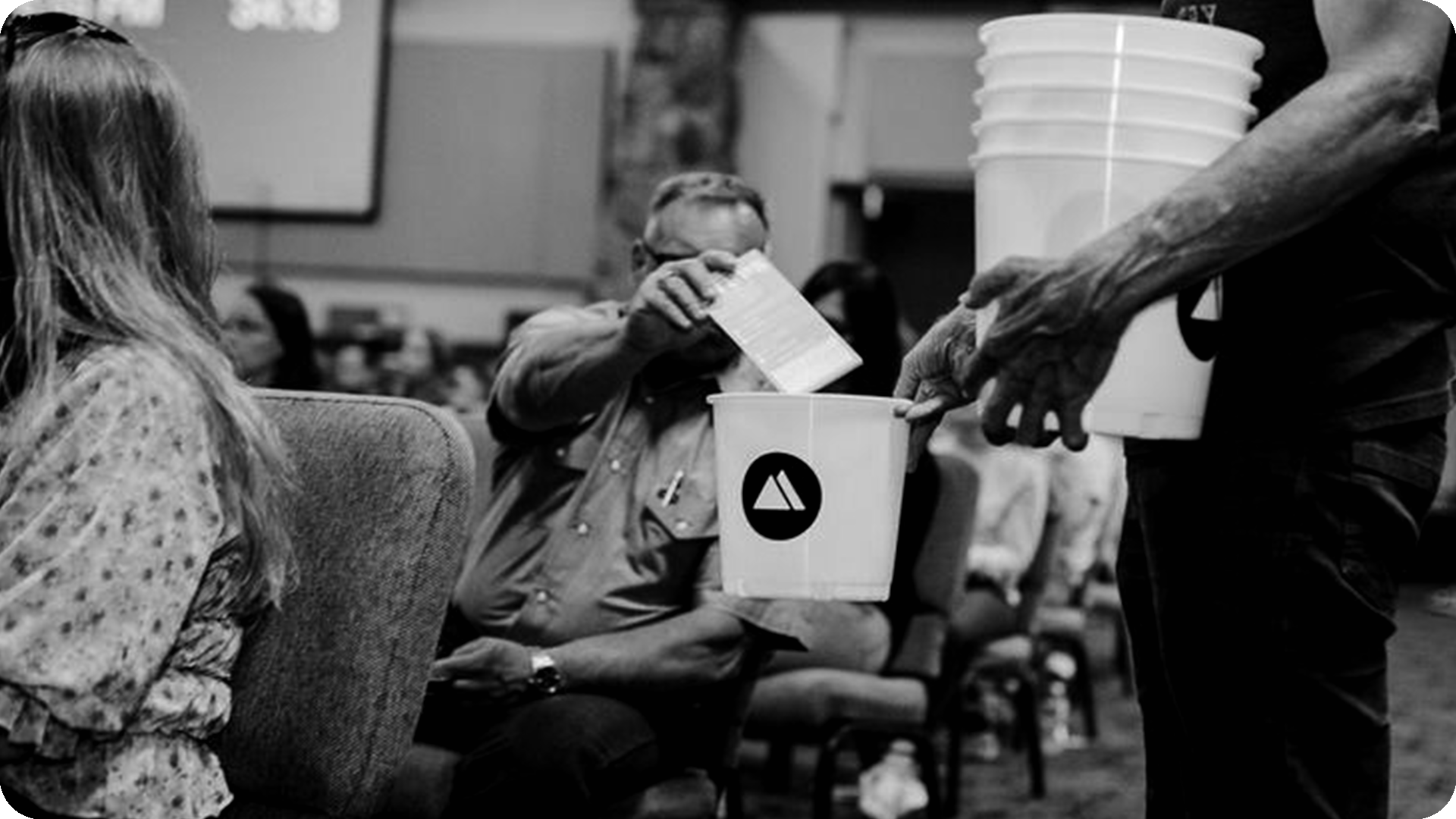 Man putting envelope in giving bucket