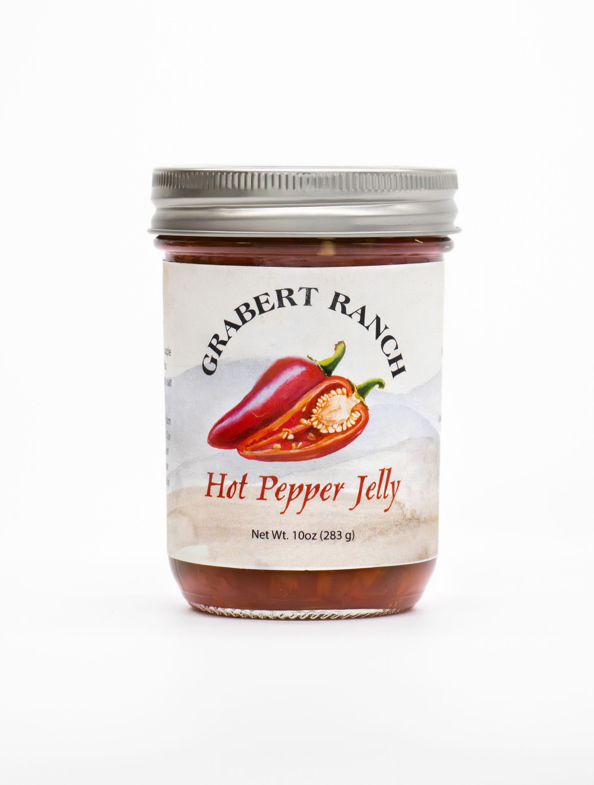A glass jar of Grabert Ranch Hot Pepper Jelly with a label featuring a red pepper illustration, set on a white background.