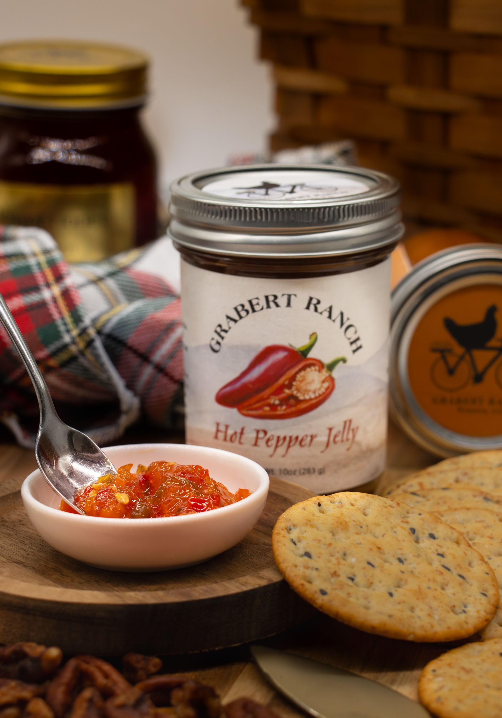 A glass jar of Grabert Ranch Hot Pepper Jelly with a label featuring a red pepper illustration, set on a white background.