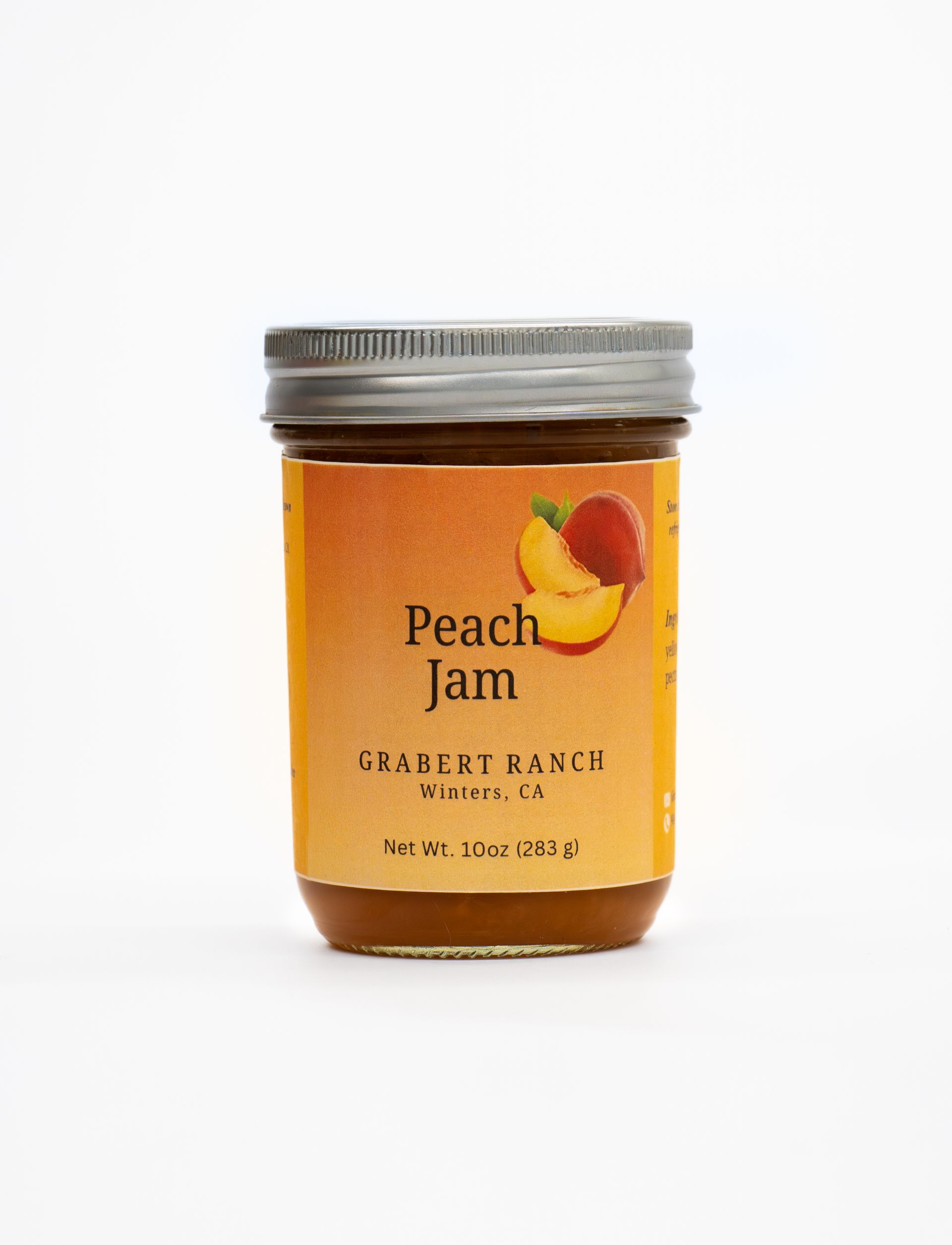A jar of Peach Jam from Juabert Ranch with a yellow-orange label featuring an illustration of sliced peaches.