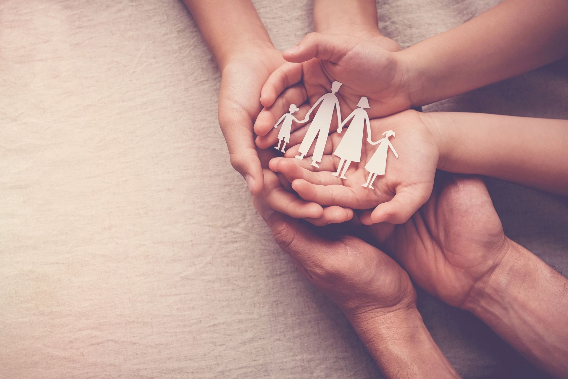 hands holding paper family cutout home