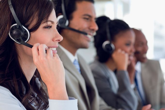 Operatori di call center con cuffie che lavorano al computer in un ufficio