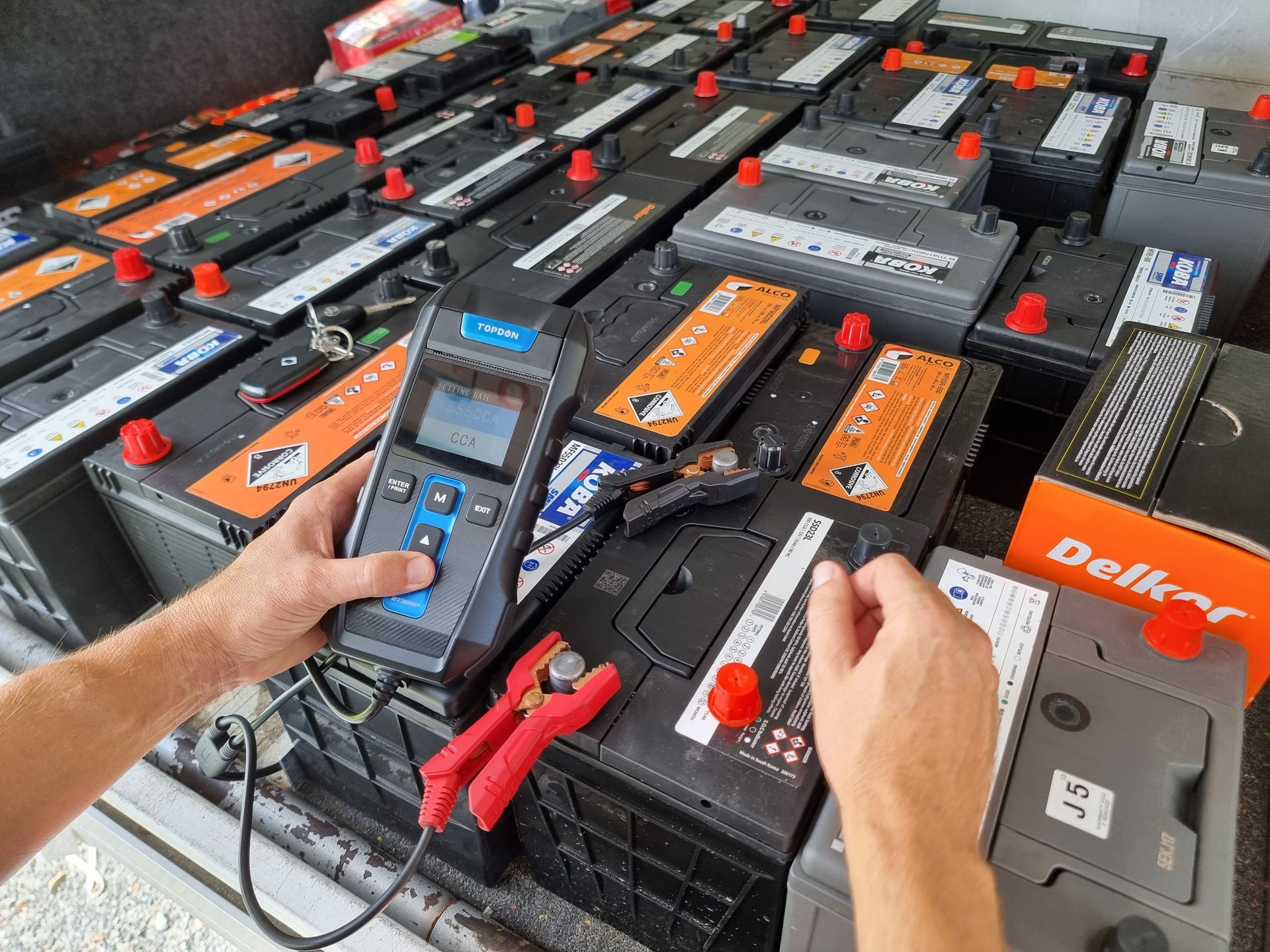 Hands Testing Car Battery Terminals With a Digital Device  — ASAP Batteries & Breakdowns in Helensvale, QLD