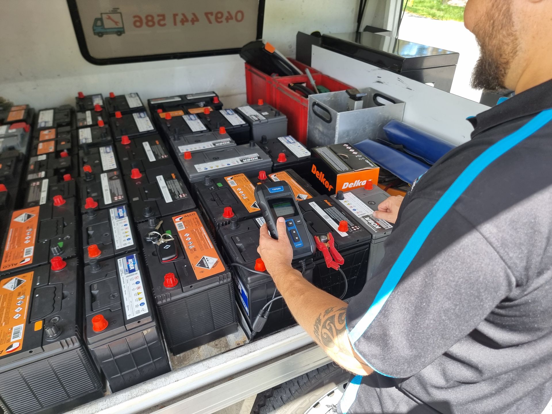 Person Testing Car Batteries in a Van — ASAP Batteries & Breakdowns in Helensvale, QLD