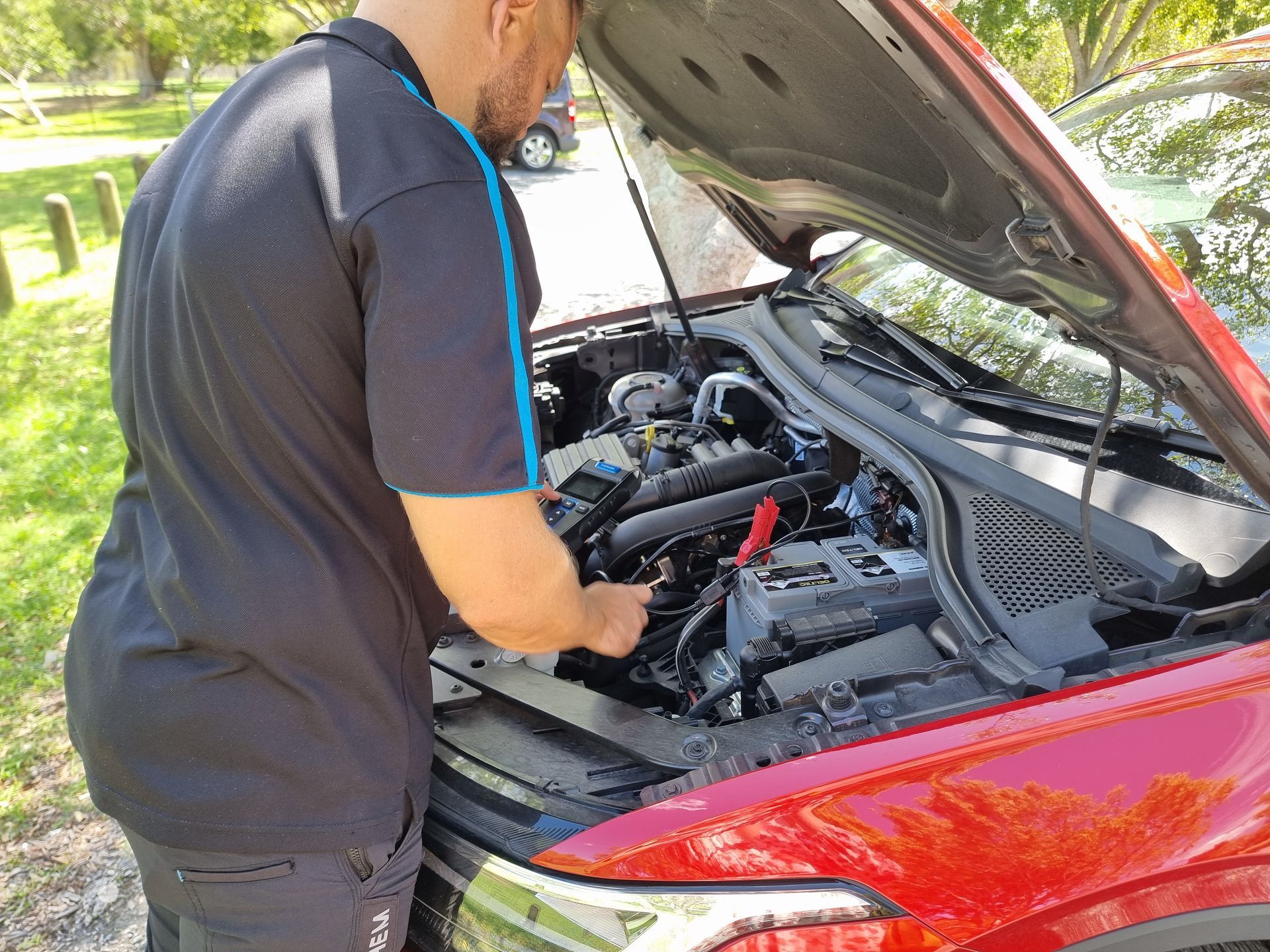 A Technician Works Under the Hood of a Red Car — ASAP Batteries & Breakdowns in Tweed Heads, NSW