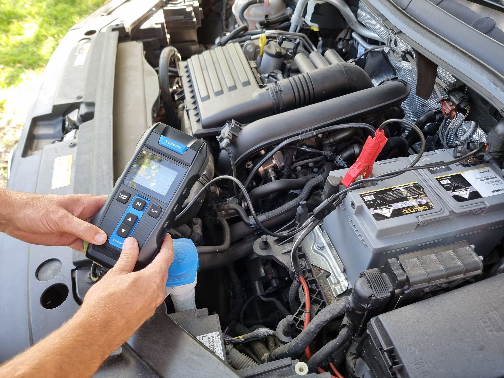 Person Holding a Battery Tester Connected to a Car Battery — ASAP Batteries & Breakdowns in Helensvale, QLD