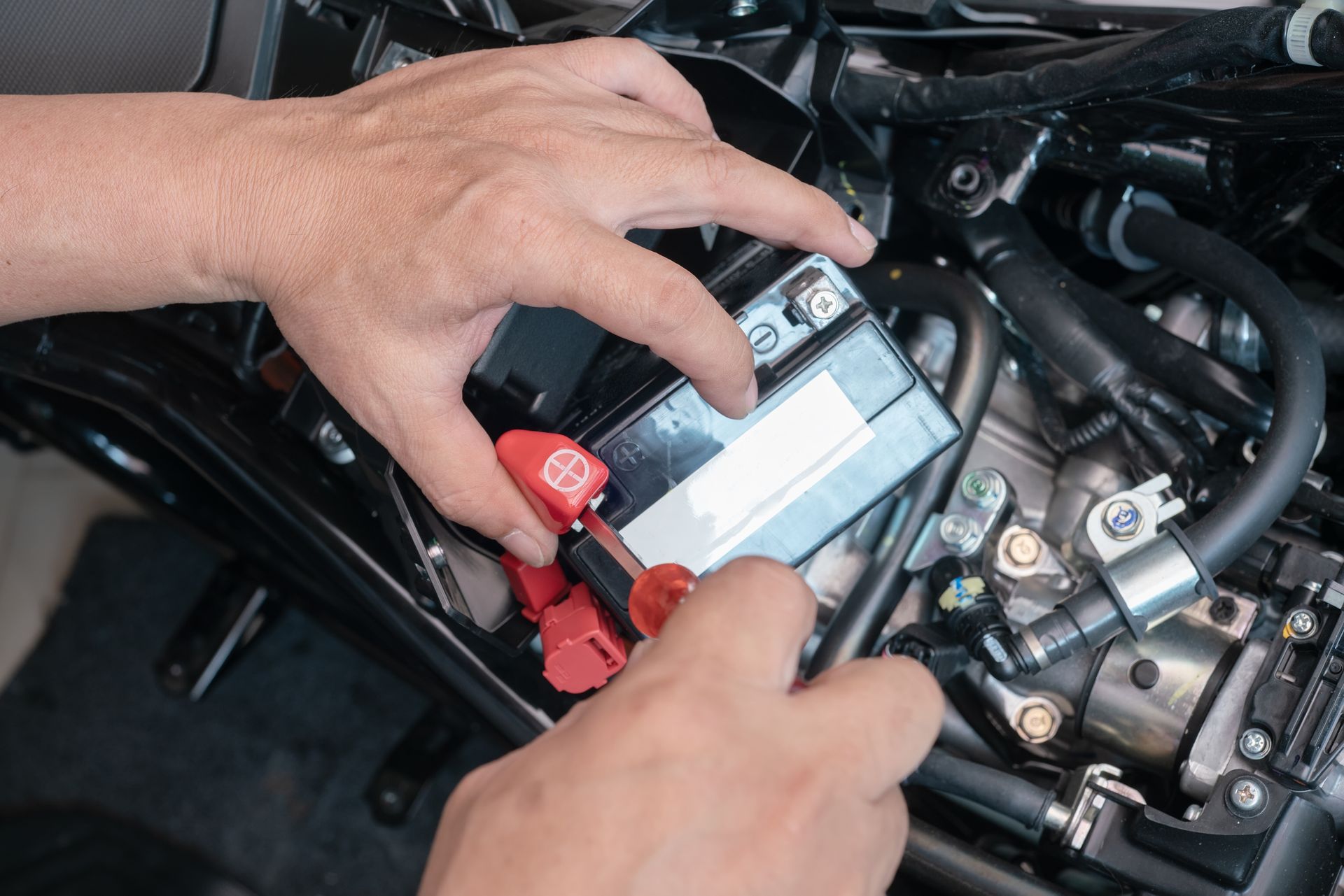 A Person Uses a Red-handled Tool to Connect a Red Cable — ASAP Batteries & Breakdowns in Tweed Heads, NSW