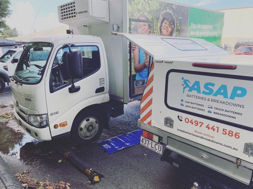 A White Refrigerated Delivery Truck Parked Next to a Utility Vehicle — ASAP Batteries & Breakdowns in Nerang, QLD