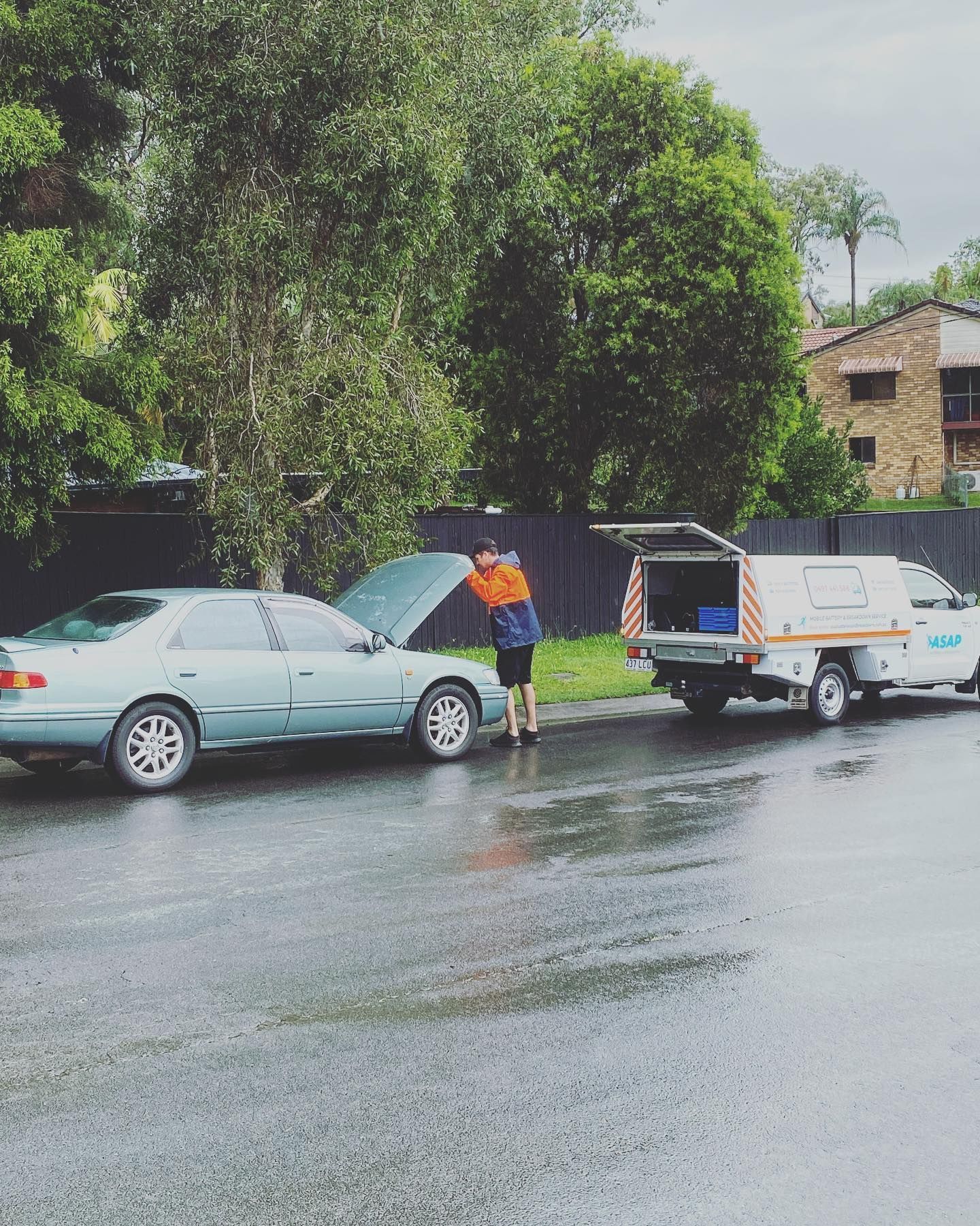 A Person in a High-visibility Jacket Inspects the Sedan — ASAP Batteries & Breakdowns in Helensvale, QLD