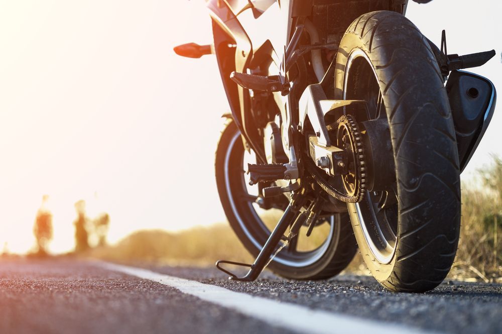 Motorcycle Parked on a Road, Tire in Focus — ASAP Batteries & Breakdowns in Helensvale, QLD