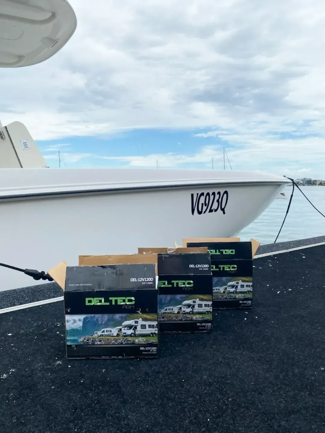 Three Gel-Tec Battery Boxes Sit on a Dock in Front of a White Boat — ASAP Batteries & Breakdowns in Helensvale, QLD