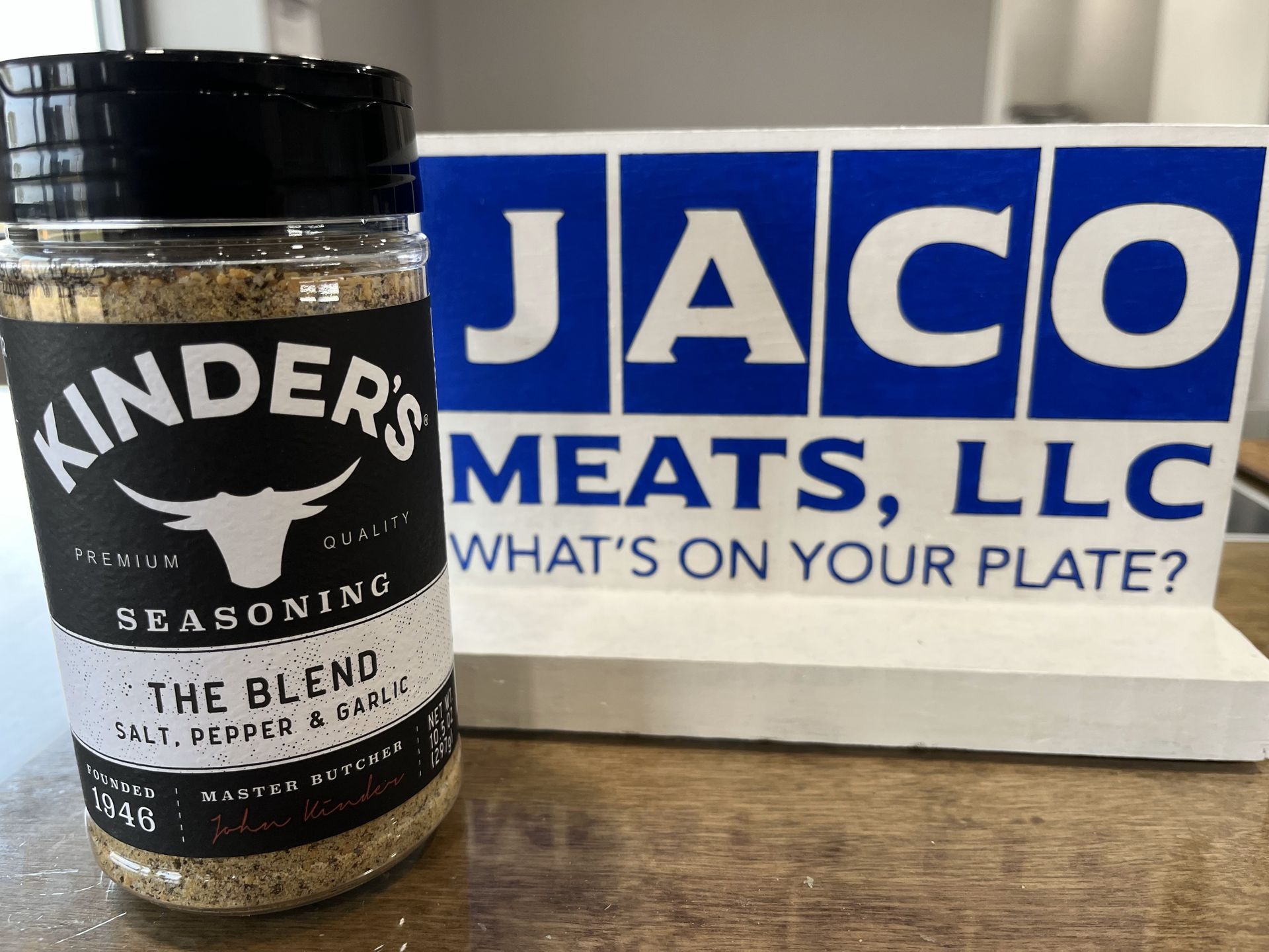 A jar of kinder 's meats seasoning next to a jaco sign