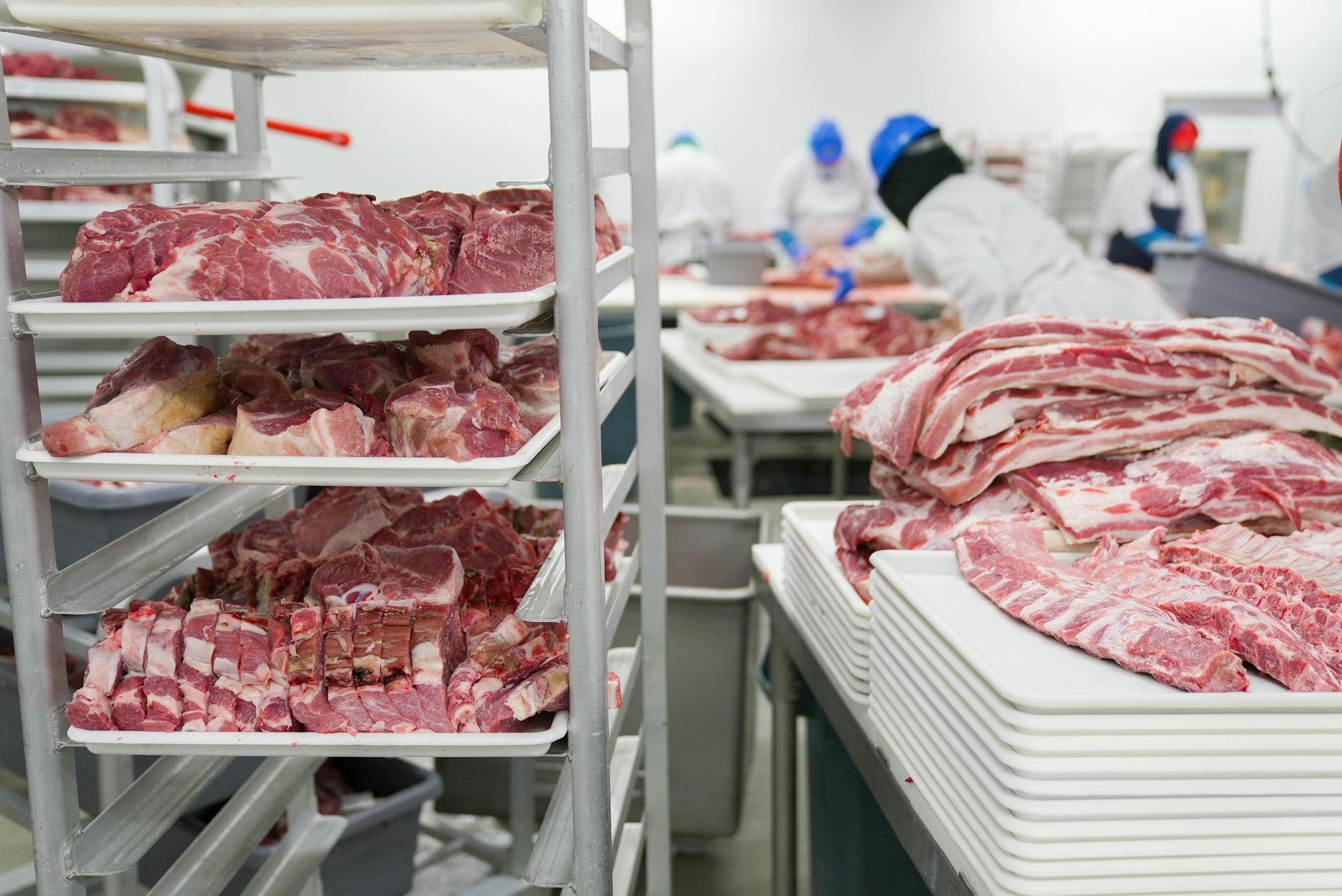 There is a lot of meat on the shelves in a butcher shop.
