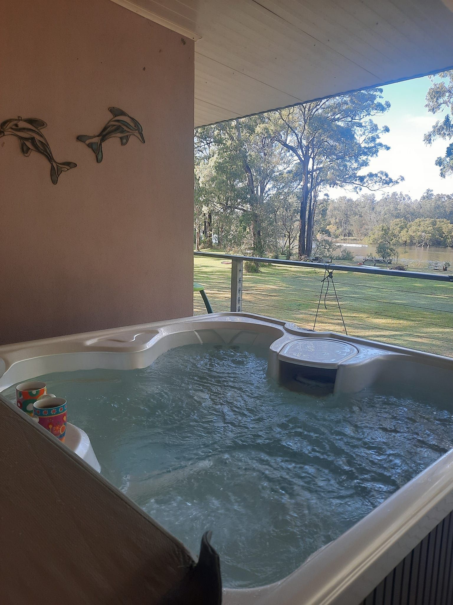 Hot Tub With Bubbling Water, Surrounded by a Stone Wall and Wooden Fence — Donna's Pool & Spa Centre In Port Macquarie, NSW