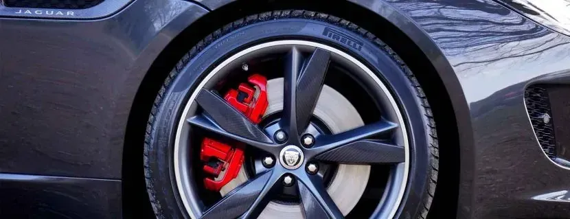 A close up of a car wheel with red brake calipers.