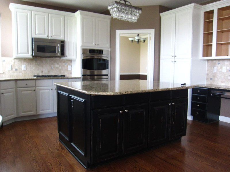 Black kitchen islands with white cabinets surrounding