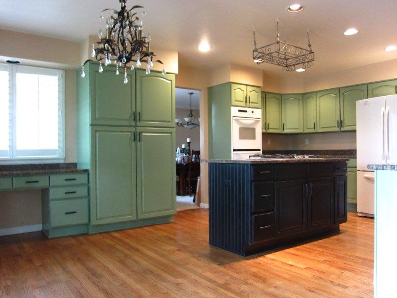 Newly painted green kitchen cabinets with dark green island in kitchen