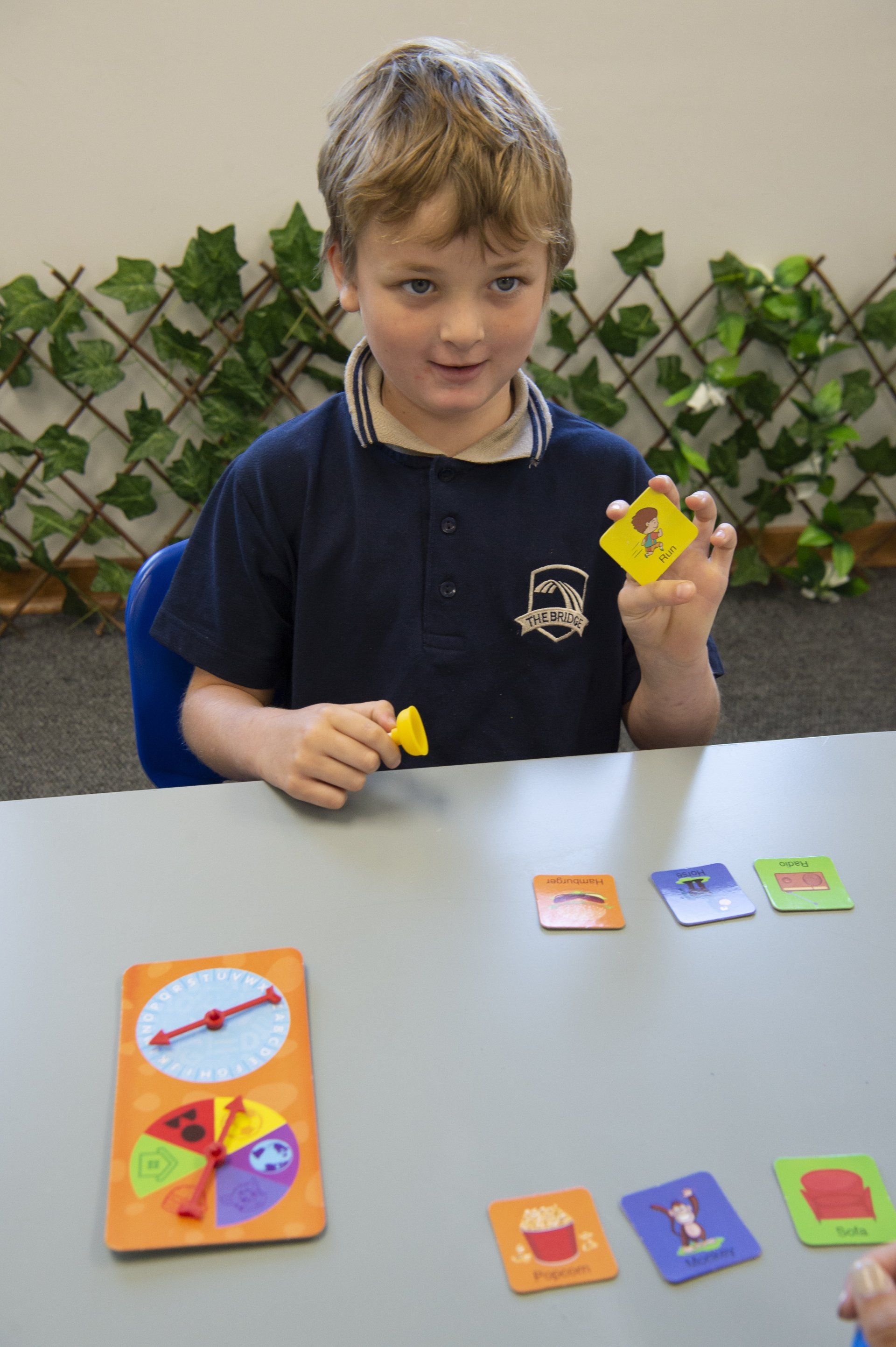 a young boy is sitting at a table playing a game
