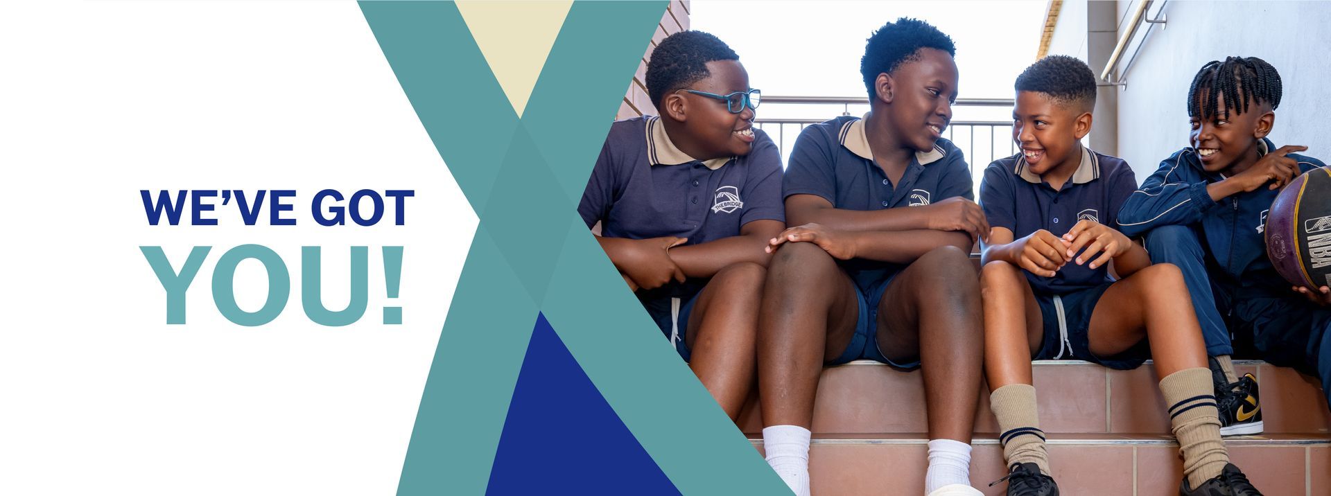 Group of school boys smiling and sitting on steps, with text 