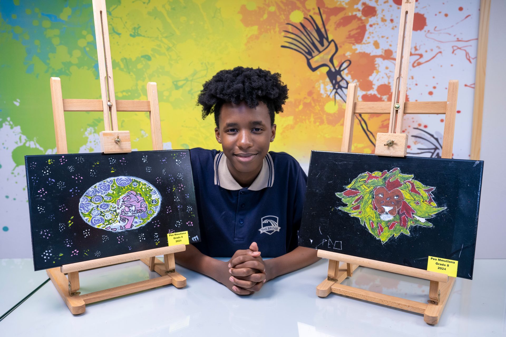 Young person with artwork of planet and animal. Against colorful splash background.