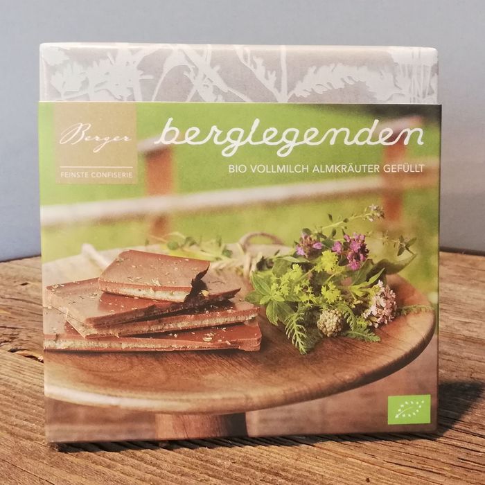 eine Schachtel Berglegenden liegt auf einem Holztisch