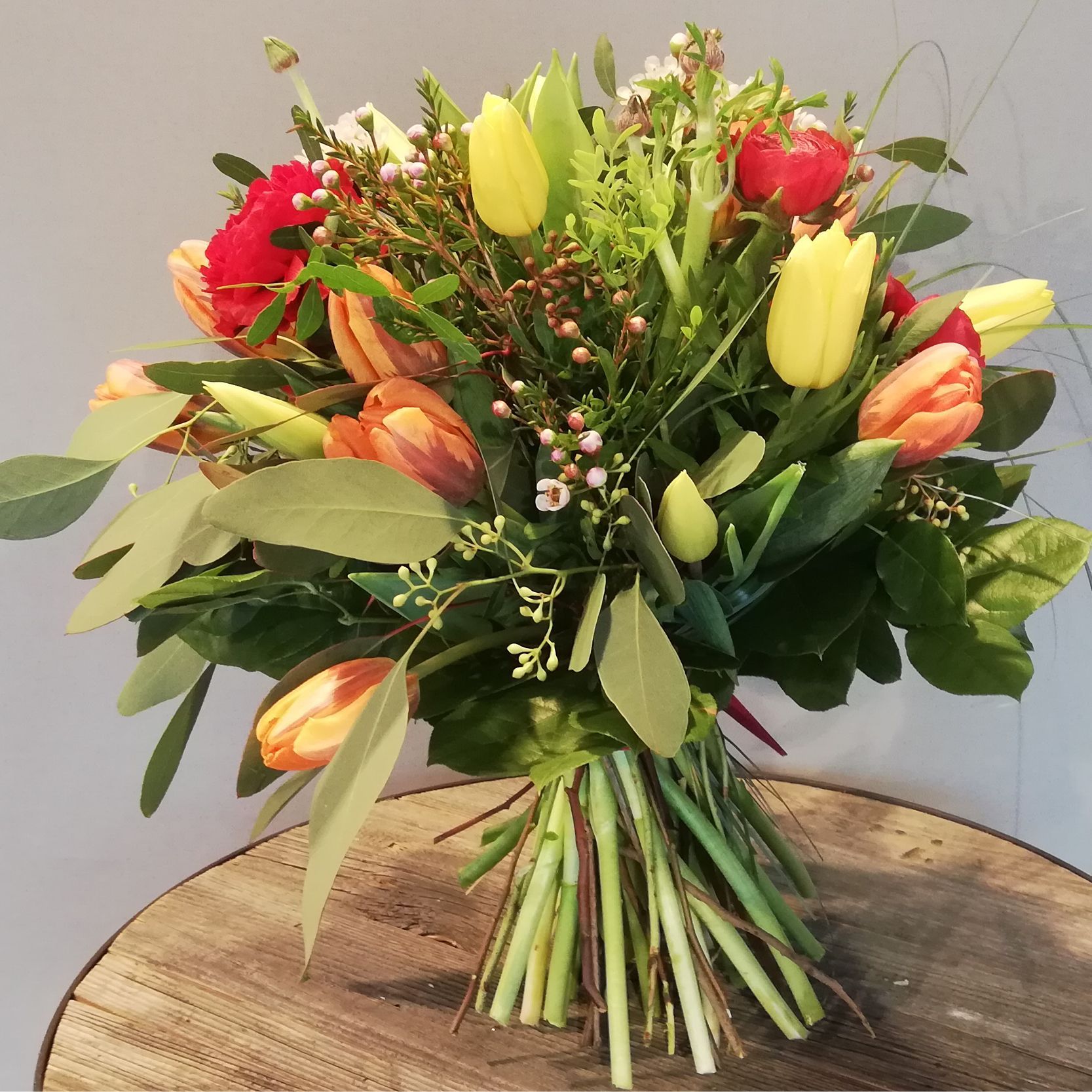 ein großer Strauß Blumen auf einem Holztisch