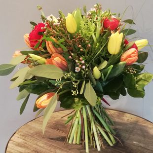 ein großer Strauß Blumen auf einem Holztisch