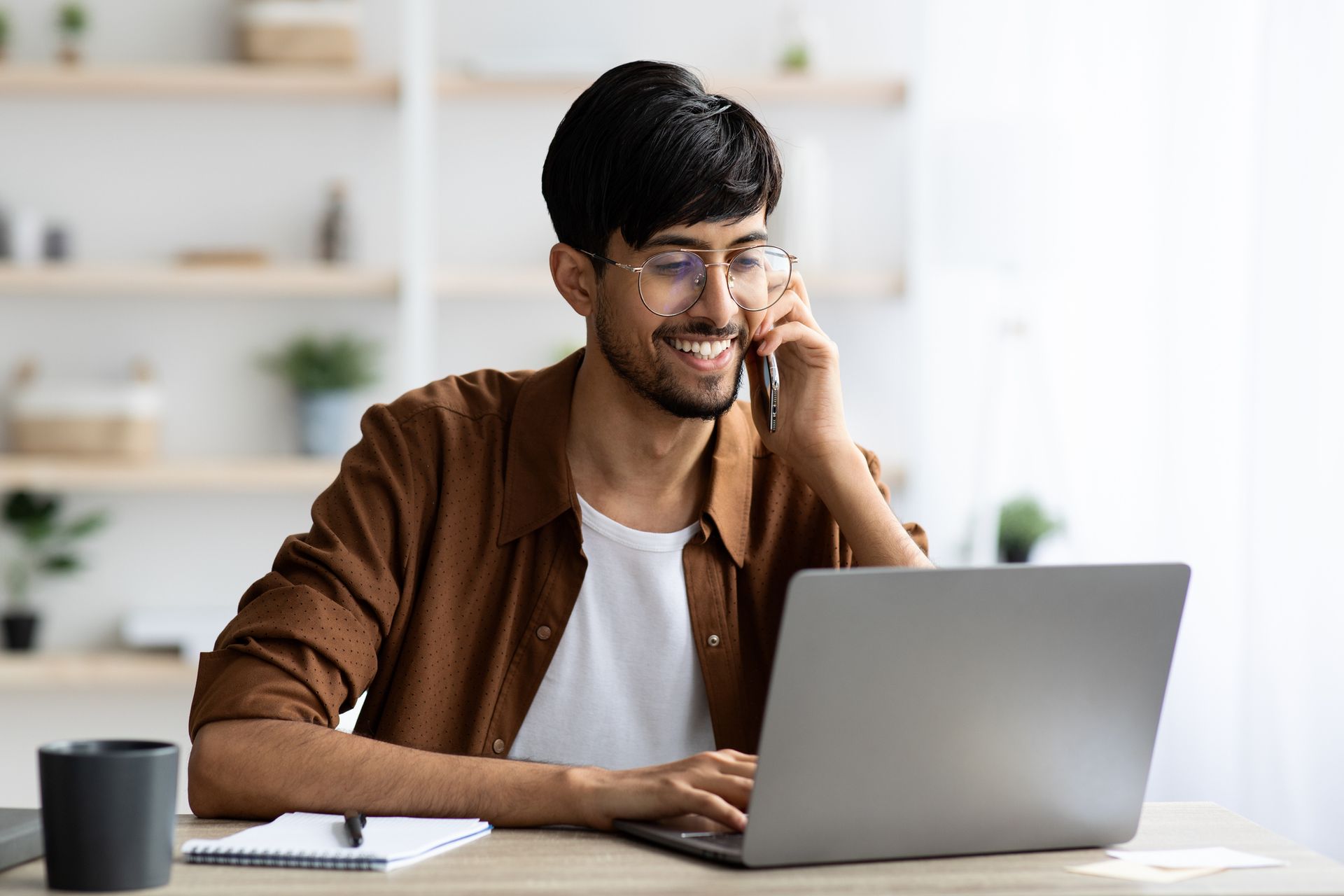 Man sitting at a table looking at his laptop